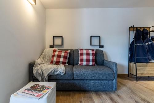 a living room with a blue couch and a table at HelloCHALET - Friends Ski House in Breuil-Cervinia