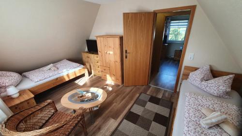 Habitación pequeña con 2 camas y mesa. en Pension am Silberberg, en Gartz an der Oder