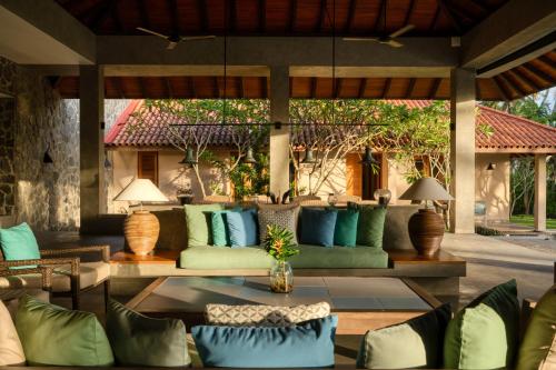 an outdoor living room with a couch and a table at Kirana - A Santani Villa in Bentota