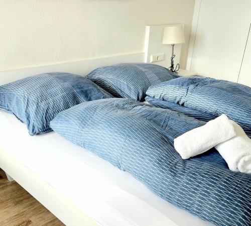 Duas almofadas azuis numa cama num quarto em Schöne Aussicht - b50247 em Hohegeiß