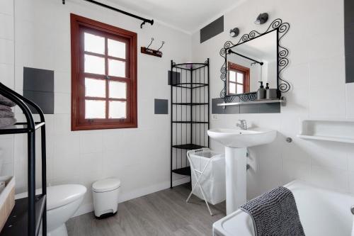 uma casa de banho branca com um lavatório e um espelho em Actors Studio em La Orotava