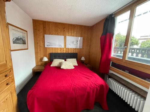- une chambre avec un lit rouge et 2 oreillers dans l'établissement Andro, à Chamonix-Mont-Blanc