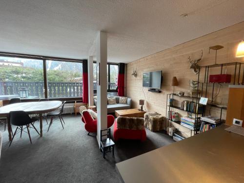 un salon avec une table, des chaises et un canapé dans l'établissement Andro, à Chamonix-Mont-Blanc