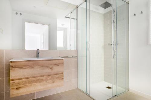 a glass shower in a bathroom with a sink at Blueground Dreta de lEixample nr pl catalunya BCN-48 in Barcelona