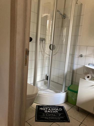 łazienka z prysznicem, toaletą i znakiem w obiekcie Conny's w Akwizgranie