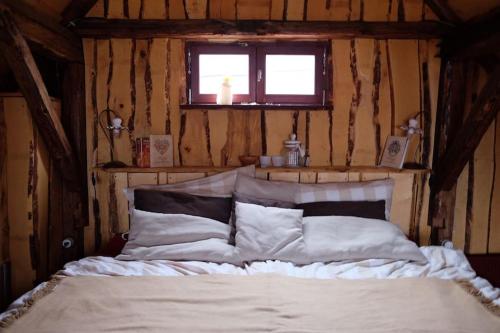 a bedroom with a white bed with a window at Wooden love nest in Vransko
