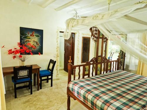 een slaapkamer met een bed, een bureau en een tafel bij Giant House Malindi in Malindi