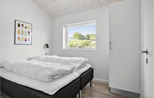 ハザスレウにあるGorgeous Home In Haderslev With Saunaの白い壁と窓が特徴のドミトリールームのベッド1台分です。
