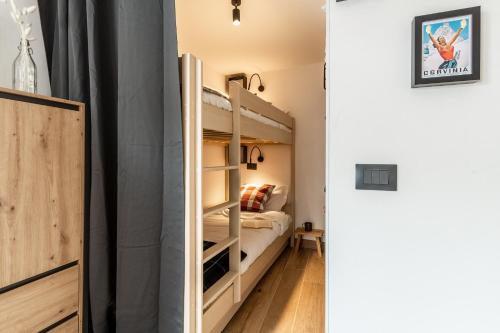 een slaapkamer met een stapelbed en een bed erin bij HelloChalet - Friends Ski House in Breuil-Cervinia