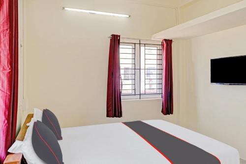a bedroom with a bed and a window at Hotel Orchid Residency Medavakkam in Chennai