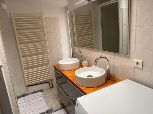 uma casa de banho com 2 lavatórios e um espelho em La Maison Bleue em Sarlat-la-Canéda
