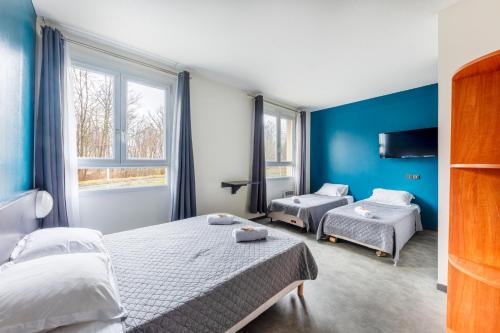 um quarto com 2 camas e uma parede azul em Hôtel La Nonette ASTERIX, CDG AIRPORT & PARIS CENTRE em Orry-la-Ville