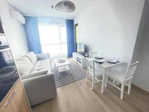 sala de estar con mesa, sofá y comedor en Sea view 2, en Varna