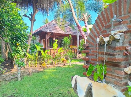 a house with a garden with a fountain in the yard at UTOPIA in Gili Islands