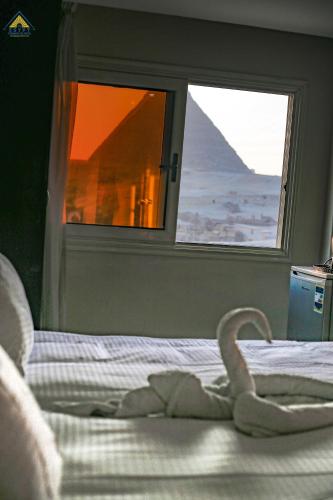 a bed with a swan on it in front of a window at Egypt Pyramids Inn in Cairo