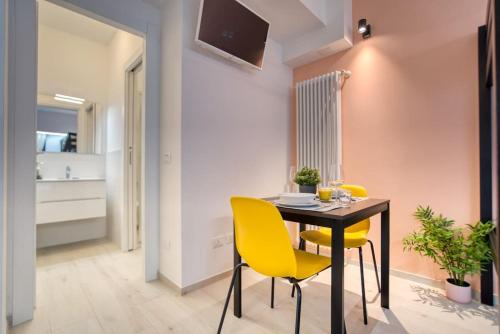 jadalnia ze stołem i żółtymi krzesłami w obiekcie Apartment Suzzani 273 - Interno A4 w Mediolanie
