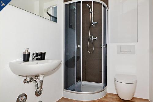 a bathroom with a sink and a shower at Haus Usedom Appartement Meeresklang in Ostseebad Koserow