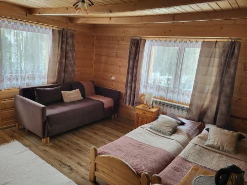 a bedroom with two beds and a couch and windows at U Parów in Białka Tatrzańska