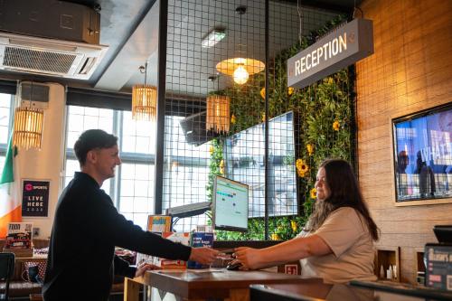 a man and a woman shaking hands in a restaurant at St Christopher's Inn Camden in London