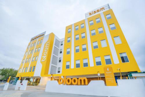 a yellow building with a sign in front of it at Bloom Hotel - Medicity Gurugram, Near Medanta Hospital in Gurgaon