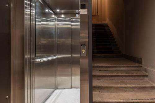 a metal elevator in a building with a staircase at San Nicolò Suites in Trieste