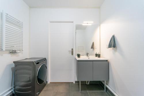 a bathroom with a washing machine and a sink at L'Œuvre dArt - Appartement avec parking privé in Noisy-le-Grand