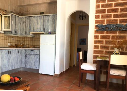 a kitchen with a refrigerator and a table and chairs at AMPELIA KYTHIRA in Livadi