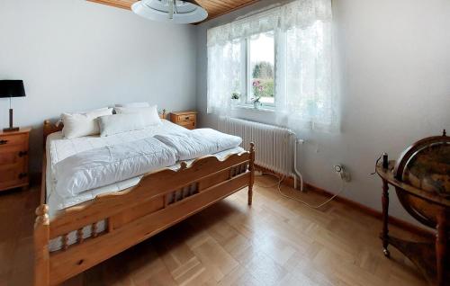 1 dormitorio con cama de madera y ventana en Amazing Home In Strmsnsbruk With Wifi, en Strömsnäsbruk