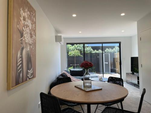 a living room with a table and chairs at Luxury 2 Bedroom Townhouse Opposite Merivale Mall in Christchurch