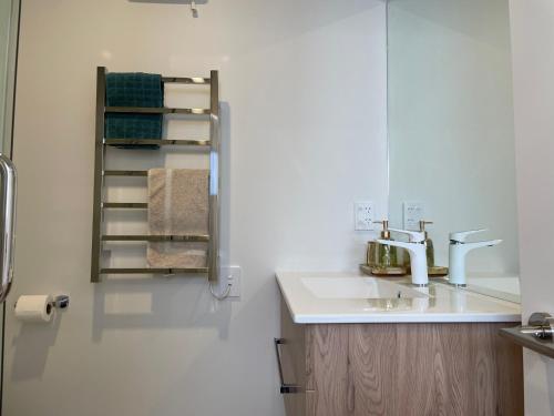 a bathroom with a sink and a towel rack at Luxury 2 Bedroom Townhouse Opposite Merivale Mall in Christchurch