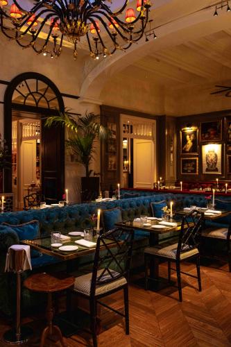 a dining room with tables and a blue couch at Maalot Roma - Small Luxury Hotels of the World in Rome