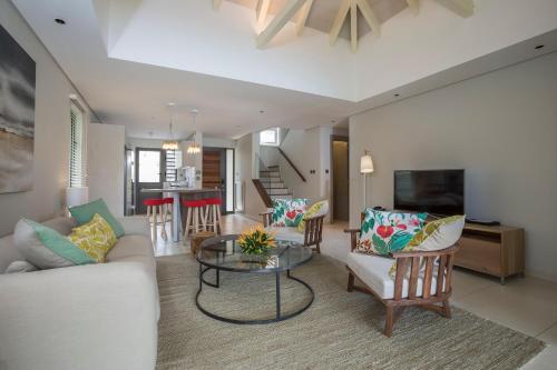 een woonkamer met een bank en een tafel bij Modern Villa with Private Pool at Anahita Golf Resort in Beau Champ