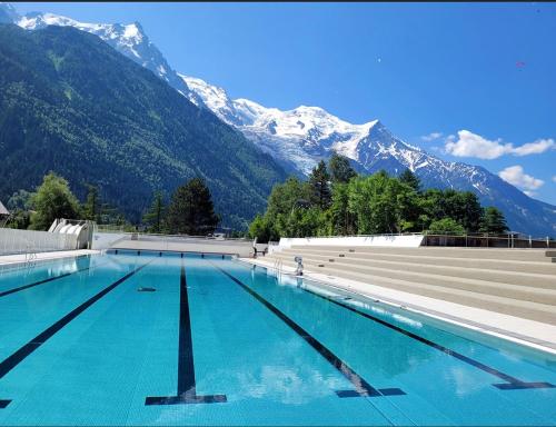 a swimming pool with snow capped mountains in the background at Andro in Chamonix-Mont-Blanc