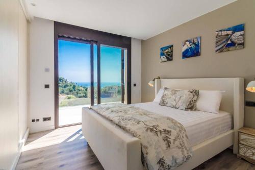 um quarto com uma cama e uma grande janela em Villa Rosalicia em Tossa de Mar