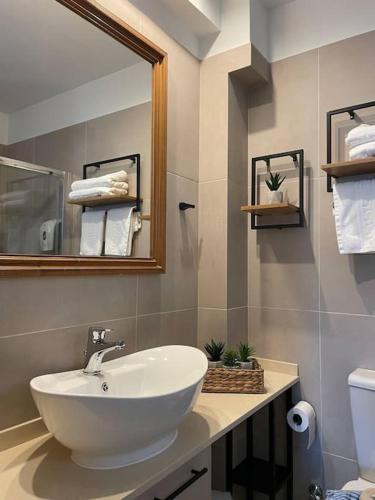 a bathroom with a white sink and a mirror at Harbour lights by Smaris Collection in Sissi