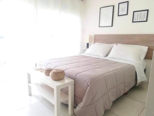 Un dormitorio blanco con una cama grande y una mesa en Lozano Studio en Buenos Aires