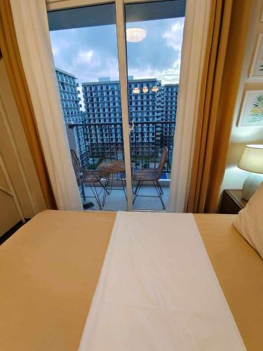 a bedroom with a bed and a view of a balcony at Jena Staycation in Lapu Lapu City