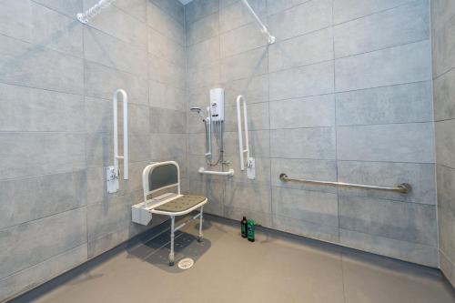 y baño con ducha y silla. en Studio Apartment with Adapted Bathroom in Liverpool, en Liverpool