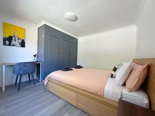 霍巴特Wellesley Mountain House near City的一间卧室配有一张蓝色橱柜和一张书桌。