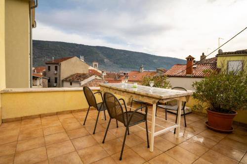 een tafel en stoelen op een balkon met uitzicht bij Aparment Kod Kule in Cres