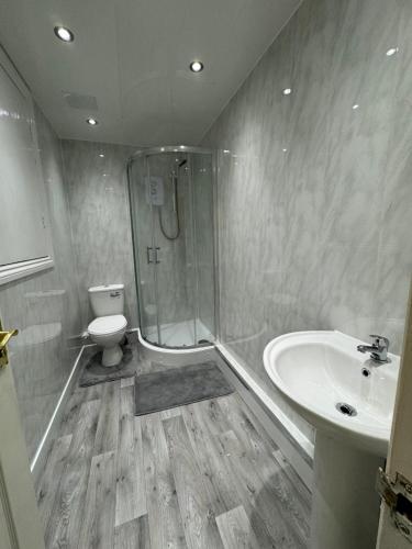 a bathroom with a shower and a toilet and a sink at Durham Home Away from Home in Durham