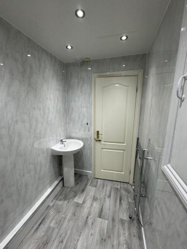 a bathroom with a sink and a door at Durham Home Away from Home in Durham