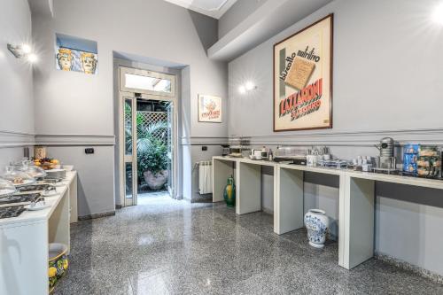 una cocina grande con encimeras blancas y puerta de entrada en Hotel La Residenza, en Messina