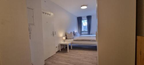 um quarto branco com uma cama e uma janela em 2-Bett Appartment im Boardinghaus Elisabeth em Dinslaken