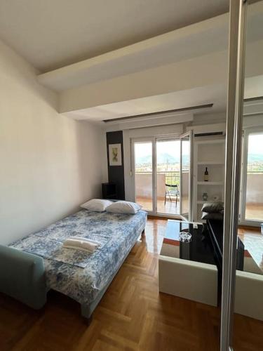 ポドゴリツァにあるStylish_apartmentの窓のある部屋にベッドがある寝室