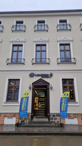 a white building with two blue signs in front of it at APARTAMENT JARACZA 28/11 in Słupsk