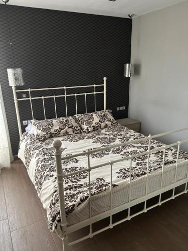 a bed in a bedroom with a black wall at Comfortable house in El Prat de Llobregat