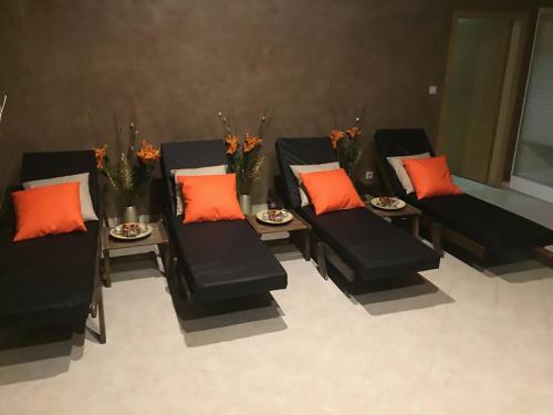 a group of black chairs and tables with orange pillows at Aspen studio Mountain retreat at Aspen Resort Golf Ski & Spa in Razlog