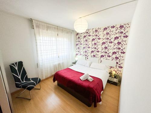 1 dormitorio con 1 cama con manta roja y silla en Escultor del Pilar ComoTuCasa en Zaragoza