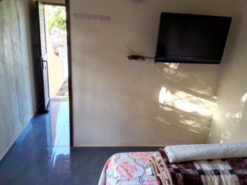a room with a wall with a tv and a couch at Recanto do Meu Tio in Chimoio